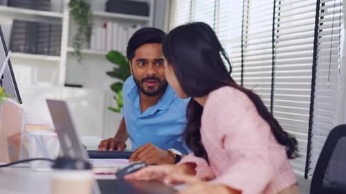 Young attractive businessman and businesswoman work in office workplace.