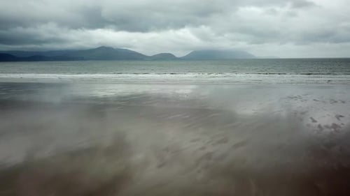 Drone view of a flat, wave-swept beach in Ireland. dingle bay. Cloudy weather
