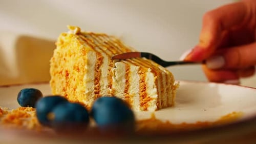 Layered Cake Slice being Cut with a Fork