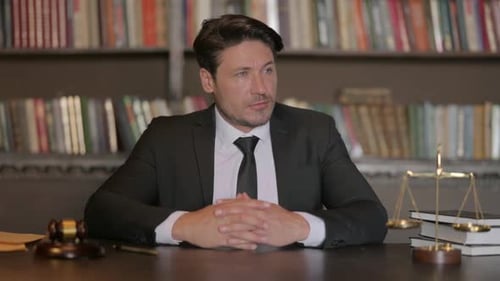 Serious Male Lawyer Sitting in Office