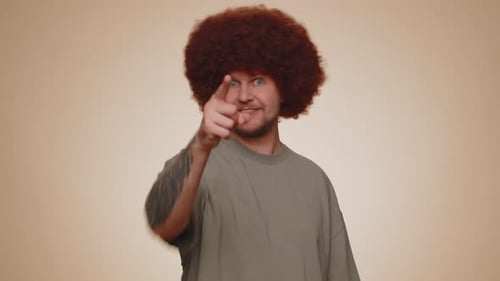 Mann lächelt aufgeregt und zeigt auf die Kamera und wählt den glücklichen Lottogewinner aus, der darauf hinweist, dass