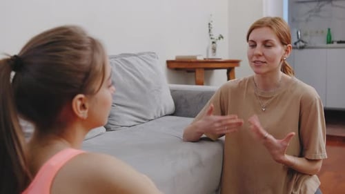 Women Talking at Home Near Grey Couch