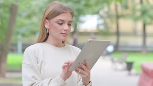 Woman Using Tablet in Urban Park Setting
