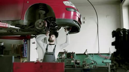 Man Mechanic Repairing A Car In A Garage.