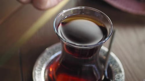 Pouring Sugar in a Traditional Turkish Tea on White Table