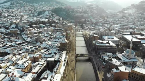 Snowy sunrise in the Bosnian capital Sarajevo. This is a still drone shot of the river Miljacka.