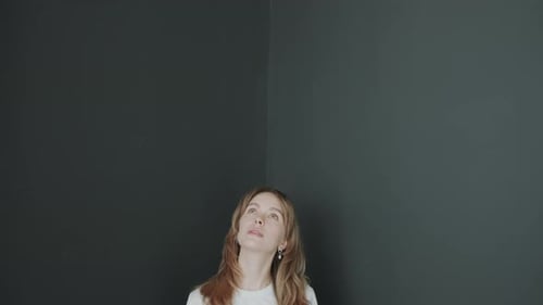 Portrait of Beautiful Blonde Woman against Dark Background in Studio