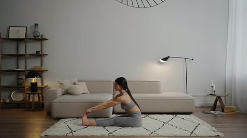 Woman Stretching on Rug in Living Room