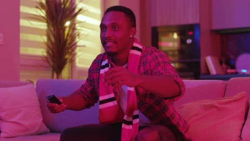 Man Watching Sports on TV Celebrates a Win