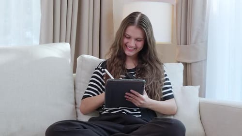 Young Woman Draws on Tablet at Home