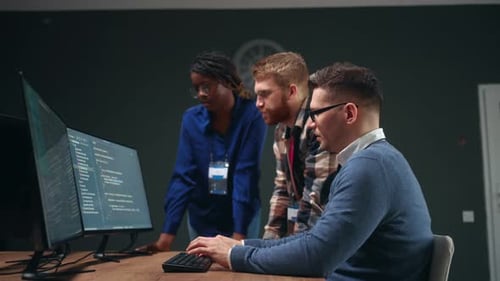 Three Multiethnic Persons Discussing Database Project in Office Programmers and Data Analysts Team