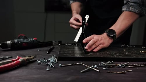 Carpenter Marking Particle Planks In Workshop