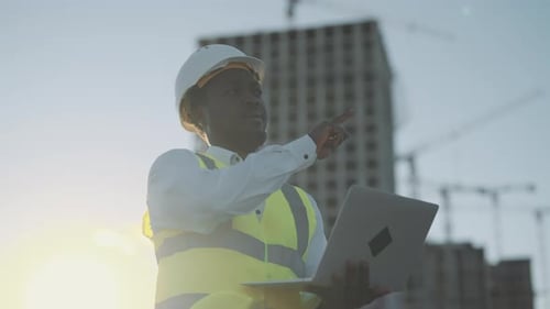 Architect Standing Against Building Under Construction Use Laptop for Project Engineer or Foreman
