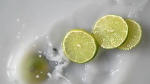Refreshing Limes Splashing in White Liquid