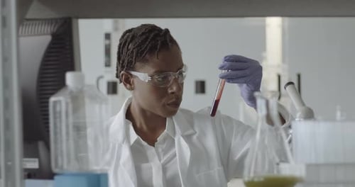 Woman Scientist Examining Blood Sample in Laboratory Setting