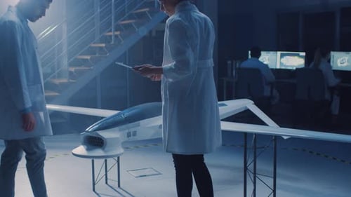 Deux ingénieurs aérospatiaux travaillent sur un prototype de véhicule aérien sans pilote/Drone. Des scientifiques de l'aviation discutent