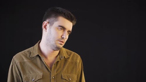 Man Making Various Facial Expressions Against Black Backdrop