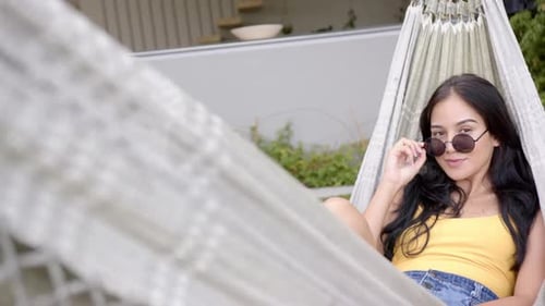 Young Woman Relaxing in Hammock on Sunny Day