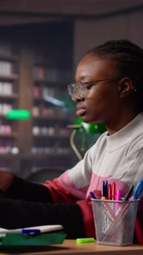 Vertical Video University Student Engrossed in Texting with Classmates at the Library