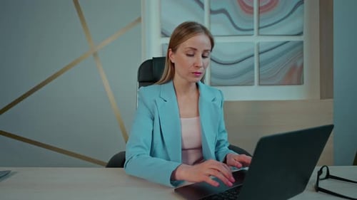 Woman Closing Laptop at Office Desk
