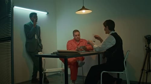 Detective Showing Evidence Bag to Convict, Male Agent Smoking by Wall in Low Key