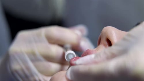 Beautician Doctor Makes Botox Injection in the Lips of Young Beautiful Woman Extreme Close Up Shot