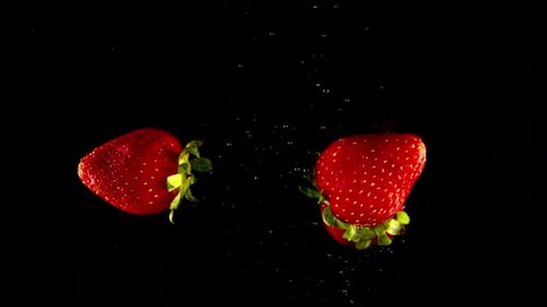 Strawberry dropping into water