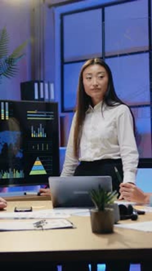 Woman Presenting Business Data to Colleagues in Office