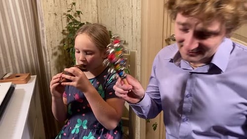 Child Plays Flute as Adult Plays Bells