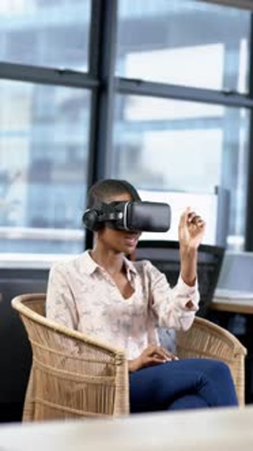 Vertical video of african american businesswoman using vr headset in office, slow motion, copy space
