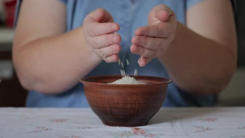 Adult Hands Pouring Rice into a Bowl