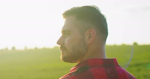 Portrait Shot of Attractive Young Caucasian Man Standing in Green Field Smiling Cheerfully and