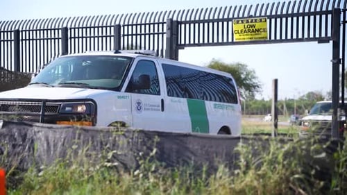 Border Patrol vehicles at fence