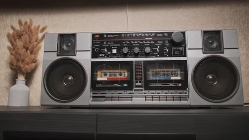 Hand presses play on a Retro Boombox