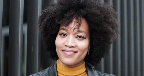 Smiling Woman with Curly Hair Poses in City