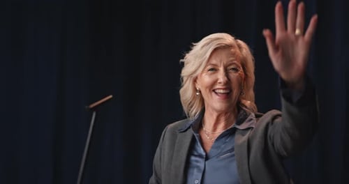 Woman Speaking at Podium Waving