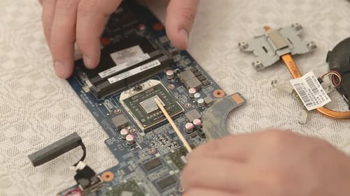 Closeup of Technician Hands Repairing Laptop Computer Cooling System