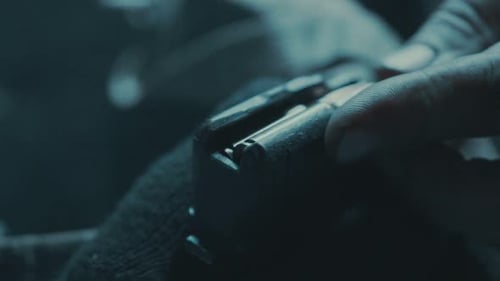 Man Loads Ammunition Cartridge into Firearm Magazine, Close-up