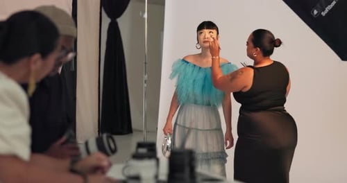 Modelo, maquilladora y maquilladora con pincel, detrás del escenario y preparación para sesiones de fotos