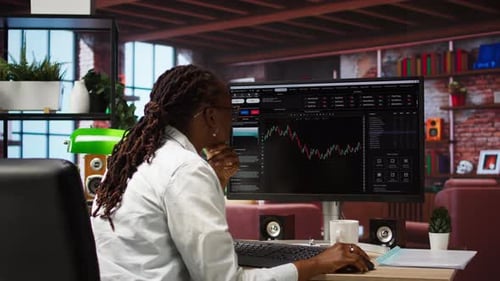 Woman Analyzing Financial Charts at Desk