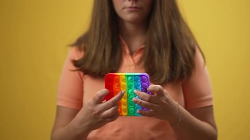 Woman Pushing Rainbow Pop-It Fidget Toy Bubbles