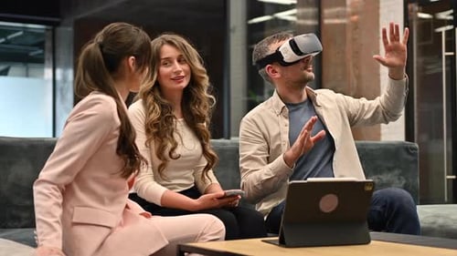 Hombre feliz que trabaja con realidad virtual puesta de cabeza en la oficina