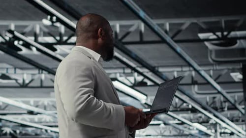 Admin Walking in Data Center Industrial Platform Analyzing Performance