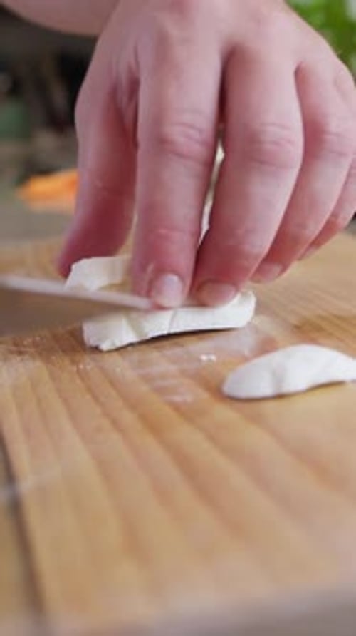 Chef Cuts Mozzarella On A Home Kitchen Cutting Board