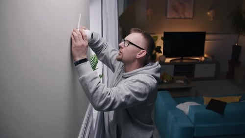 Mann stellt Sicherheitskamera auf die Wandhalterung