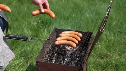 Sausages roasting on barbecue grill outdoors. Grilled food fried and smoked in charcoal grills.