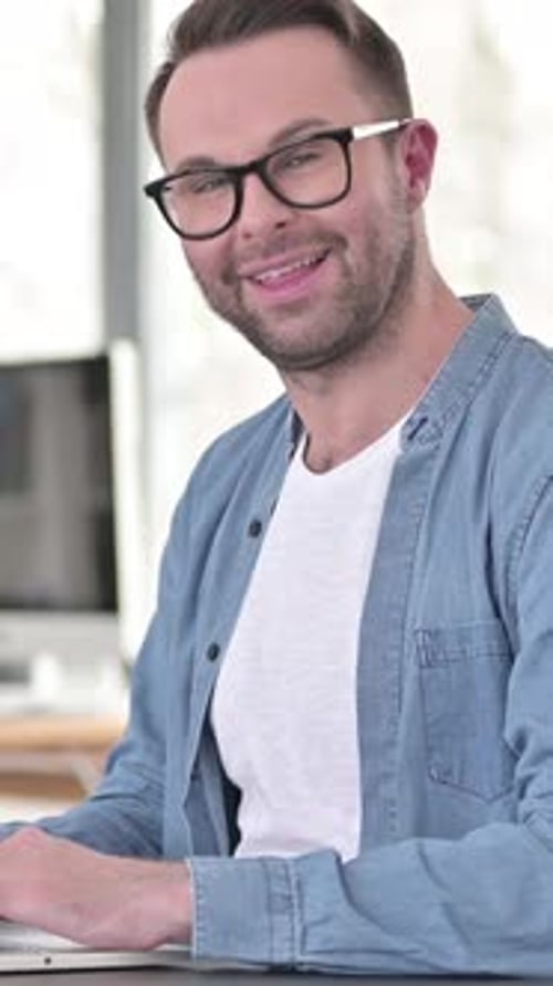 Man Working on Laptop Gives Thumbs Up Gesture
