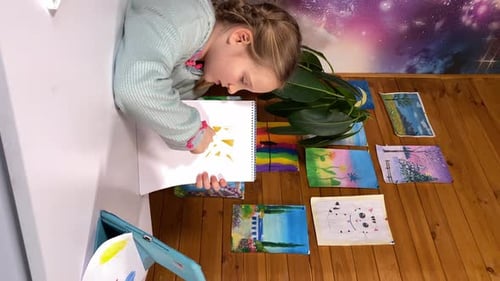 Girl Drawing Picture on Table with Art Supplies