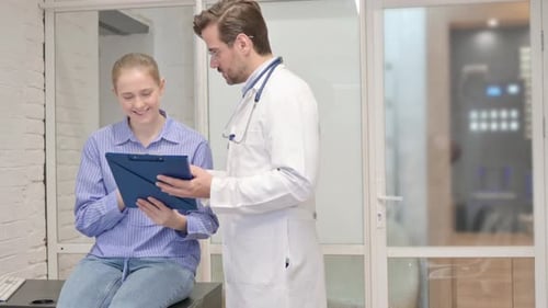 Doctor Reviews Medical Information With Young Patient