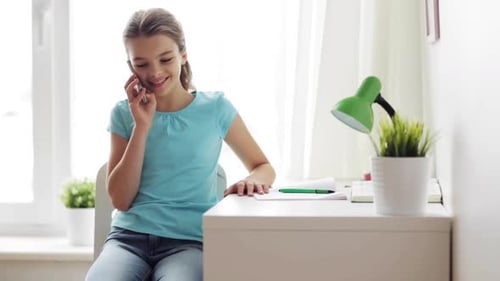 Smiling Girl Talking on Phone at Desk